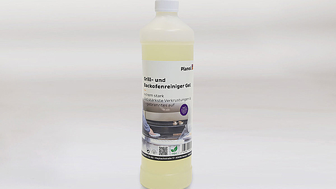 Flasche mit gelbem Reinigungsmittel und Etikett des Grill- und Backofenreinigers vor grauem Hintergrund